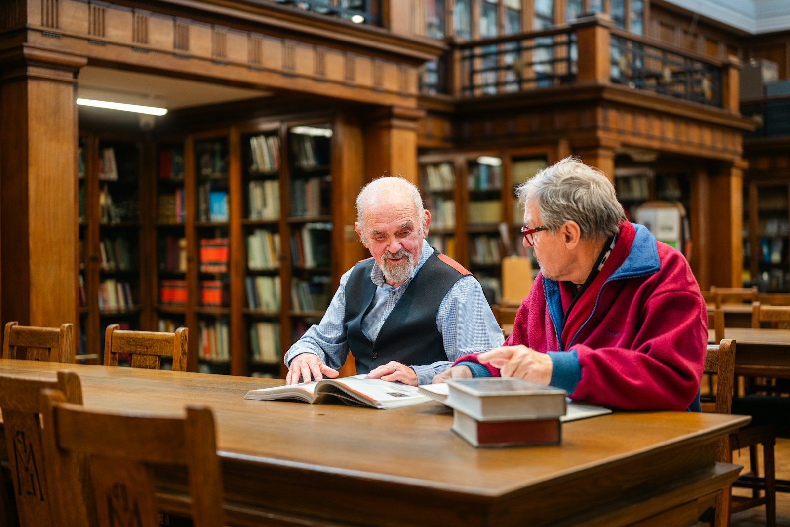 Two men studying books in a library.