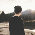 tilt shift lens photography of man standing near body of water
